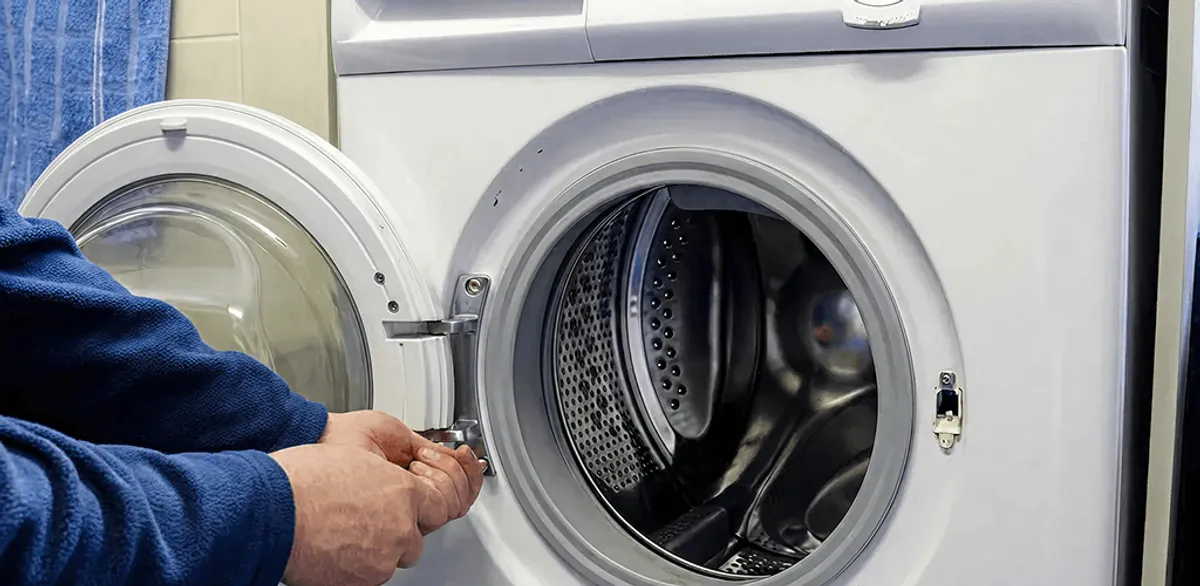 Washing machine repair handyman checking a front-load washer door and latch in Houston, TX