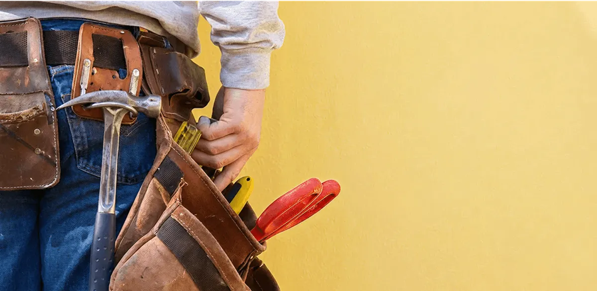 Handyman with tool belt ready for home repairs and maintenance in Houston, TX