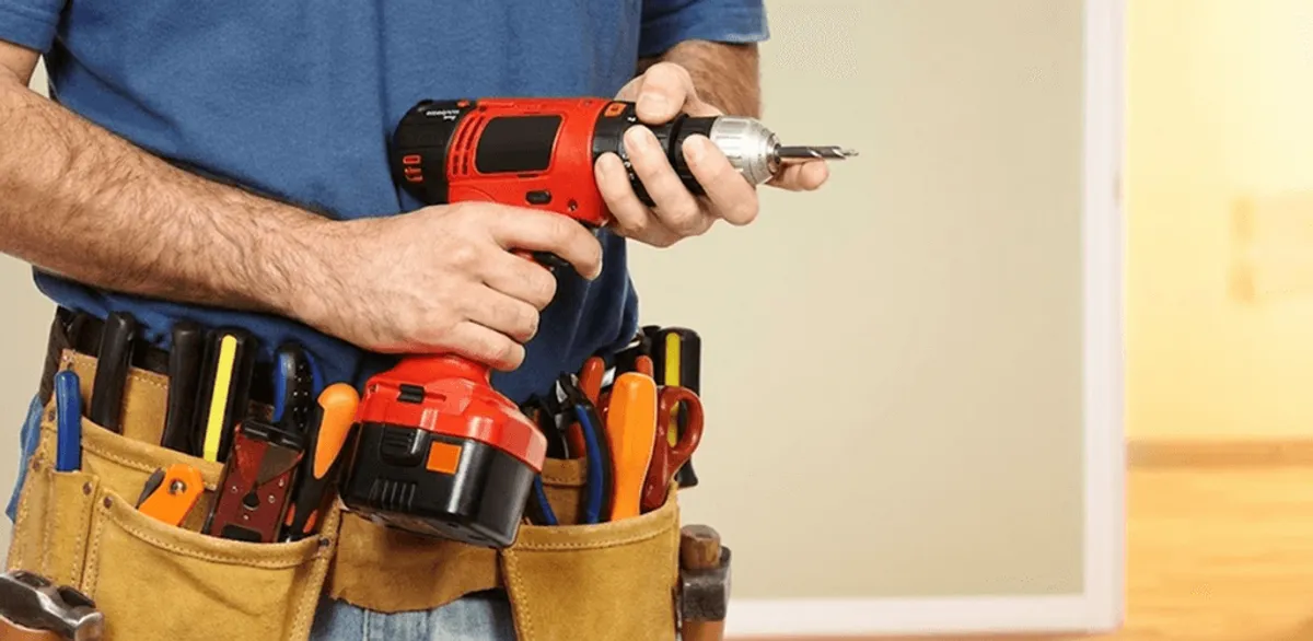 Handyman holding a power drill for home repairs and installations in Houston, TX