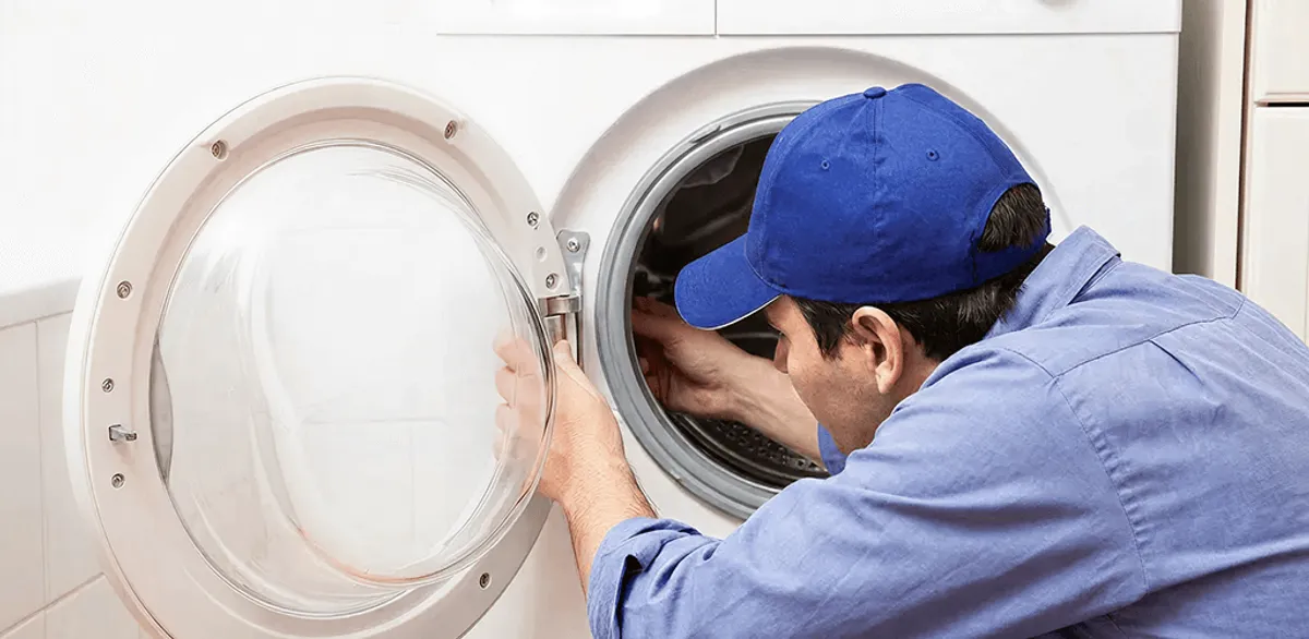 Washing machine repair handyman inspecting a front-load washer drum in Houston, TX